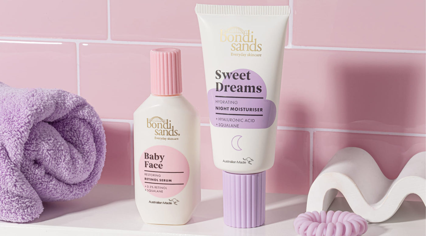 Two skincare products, 'Baby Face' and 'Sweet Dreams', from Bondi Sands on a bathroom counter with a pink towel and soap.