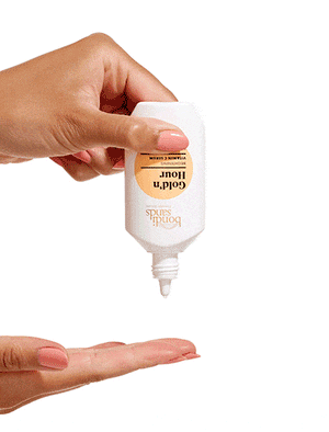 Drop of gold'n hour vitamin c serum onto fingers